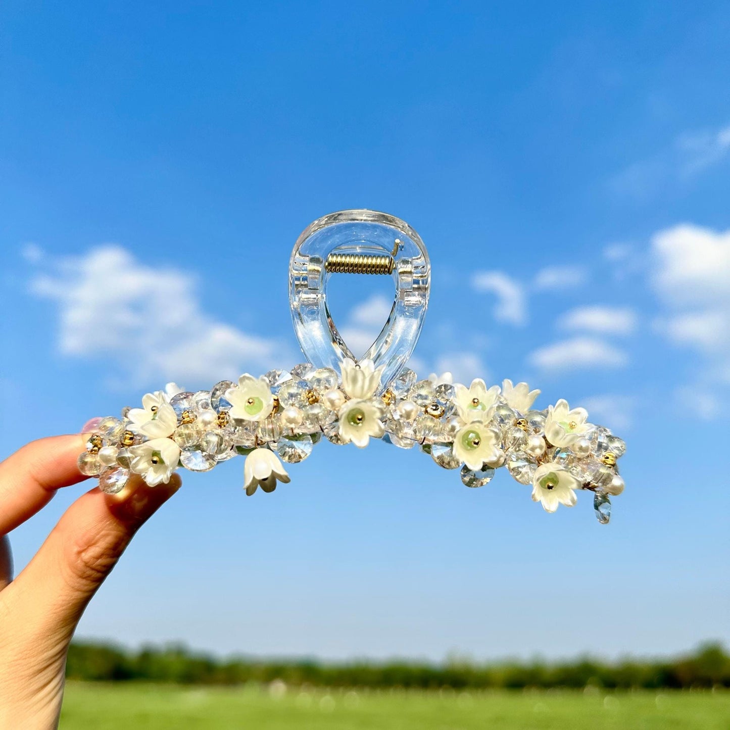 a hand holding a head piece with flowers on it