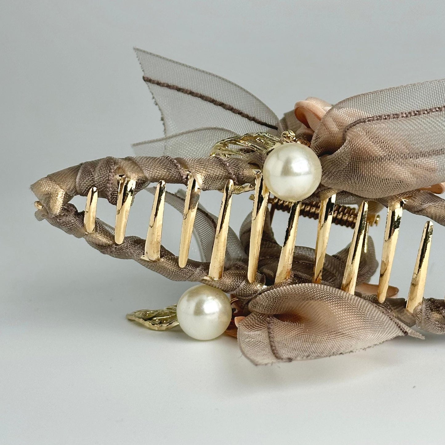 a hair comb with pearls and a bow on it
