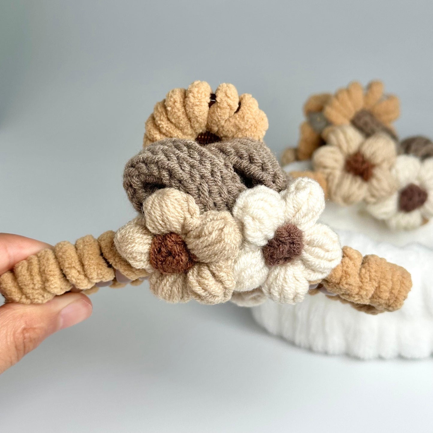 a hand holding a rope with crocheted flowers on it