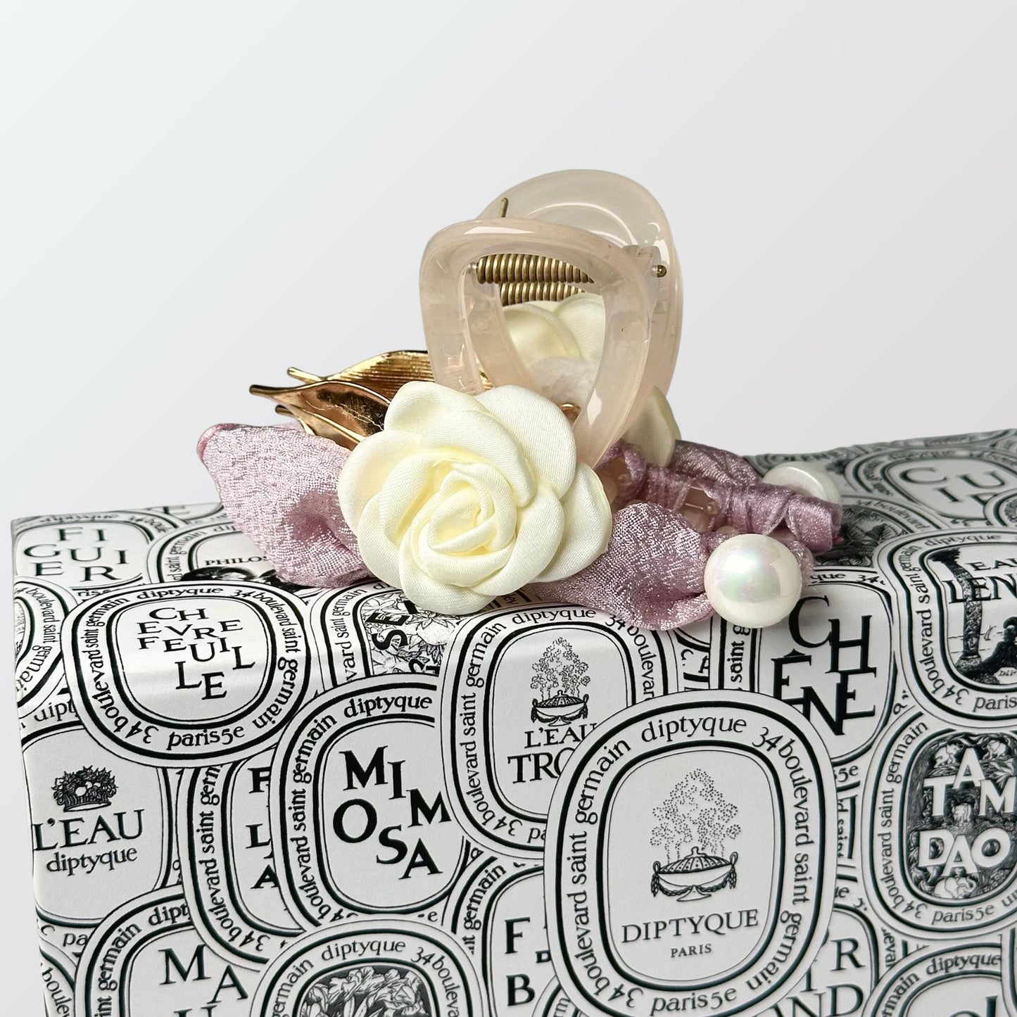 a white rose sitting on top of a black and white bag
