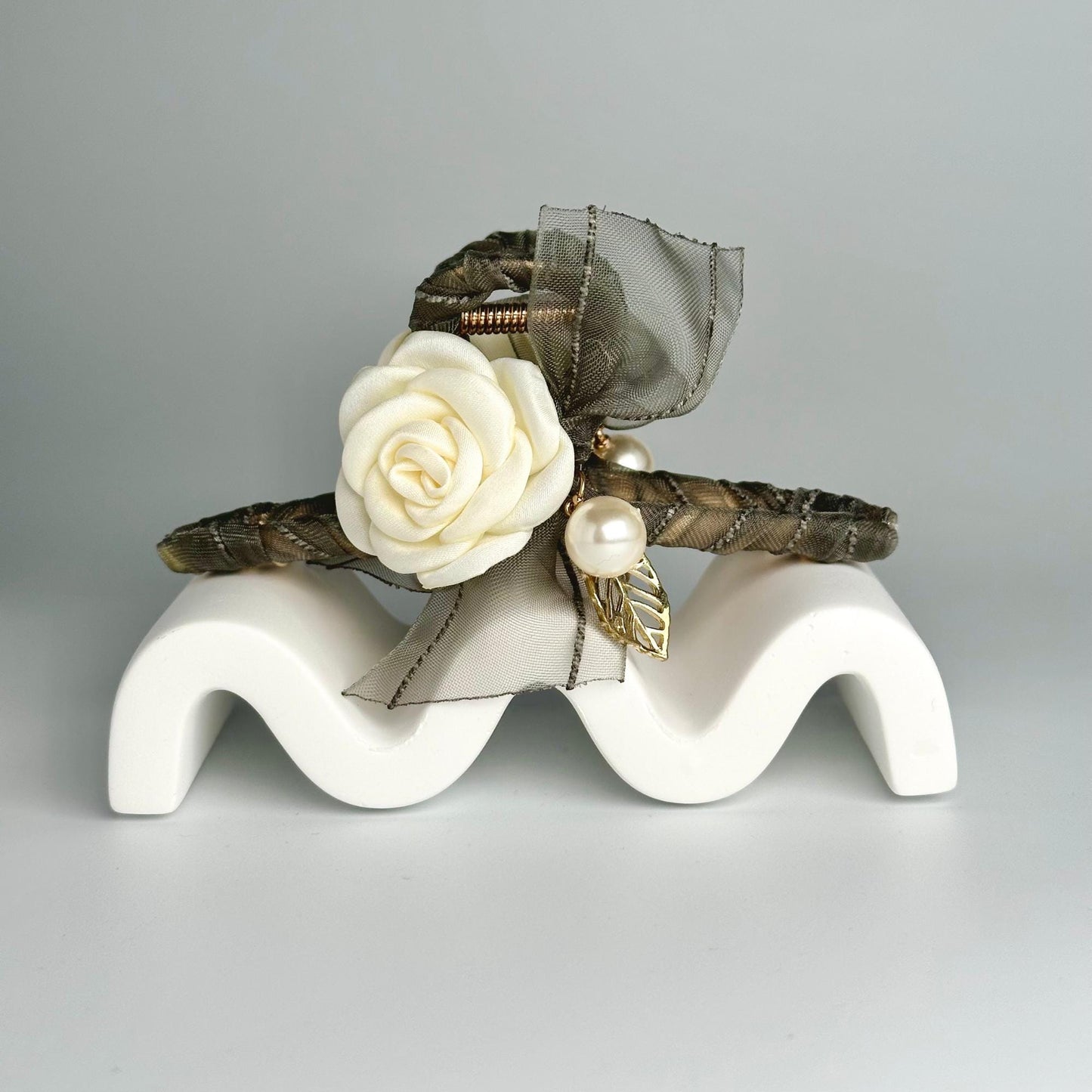 a white rose sitting on top of a white sculpture