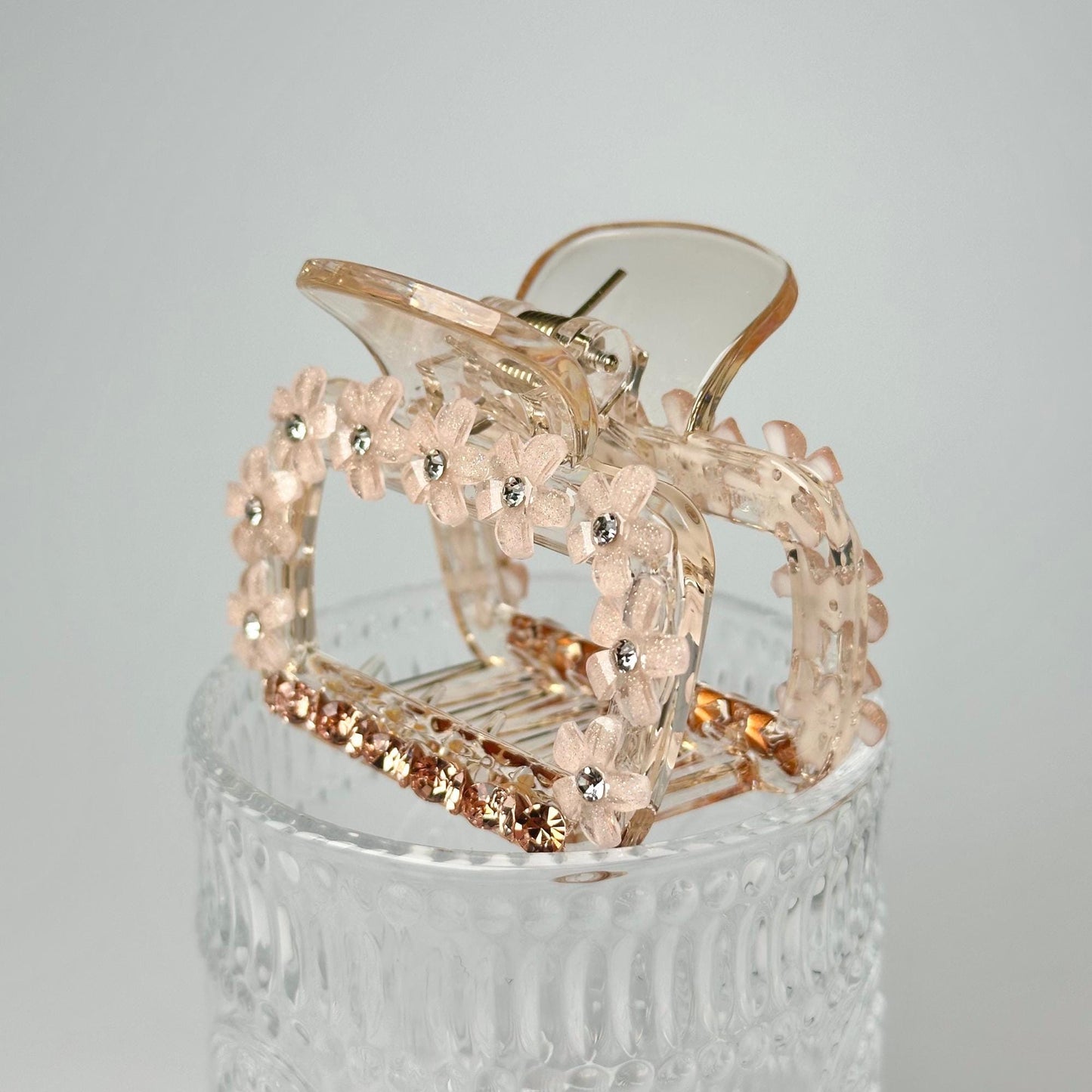 a clear glass container with a gold colored object in it