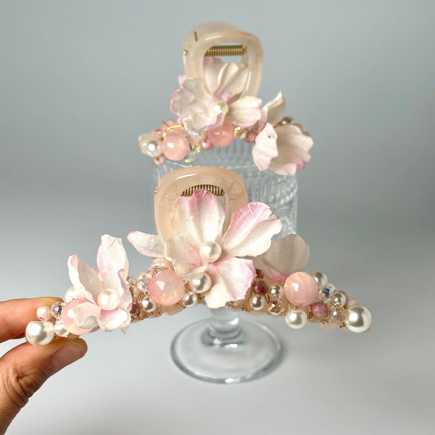 a hand holding a hair comb with flowers on it