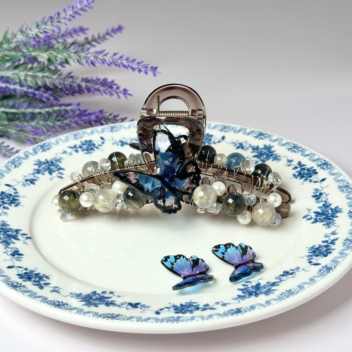 a blue and white plate with a butterfly brooch