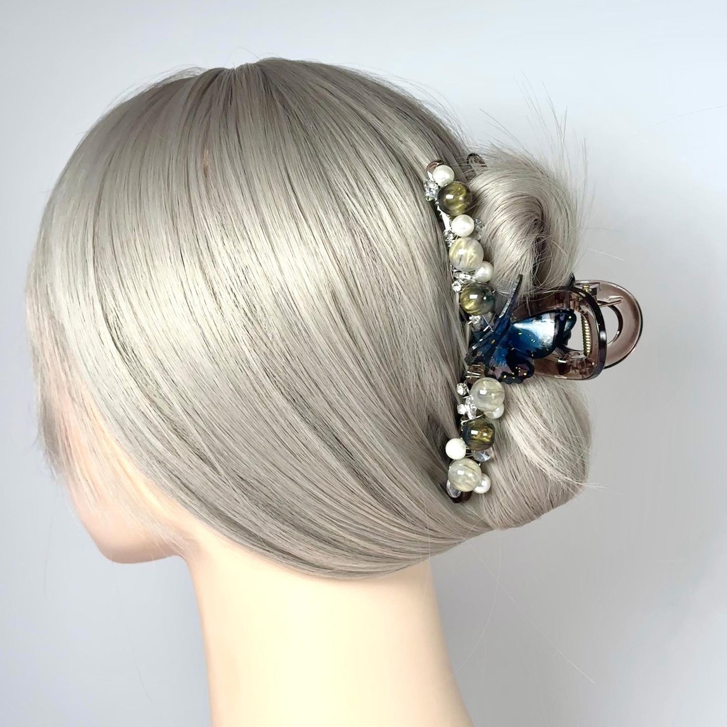 a woman's head with grey hair and a hair clip