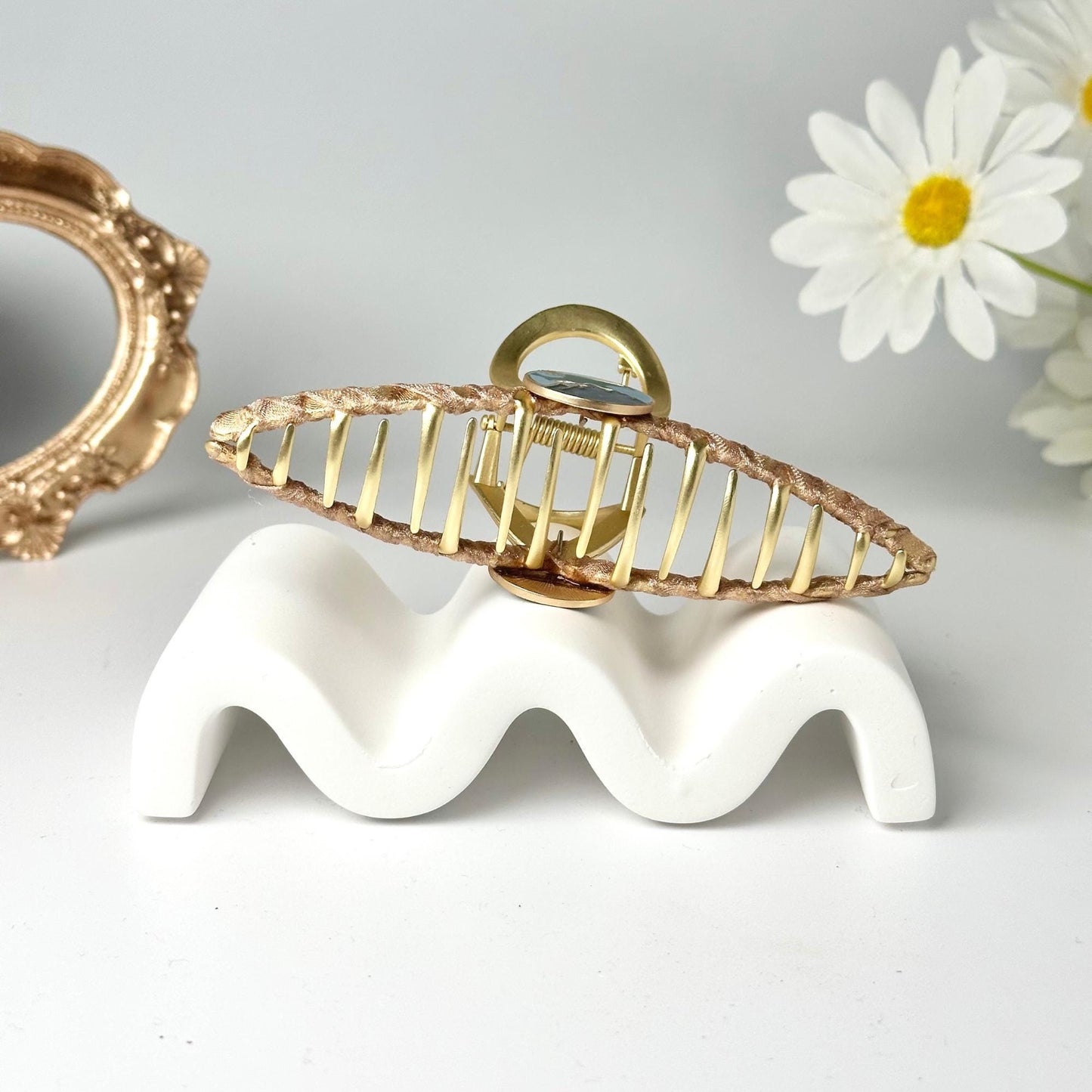a gold and white brooch sitting on top of a white table