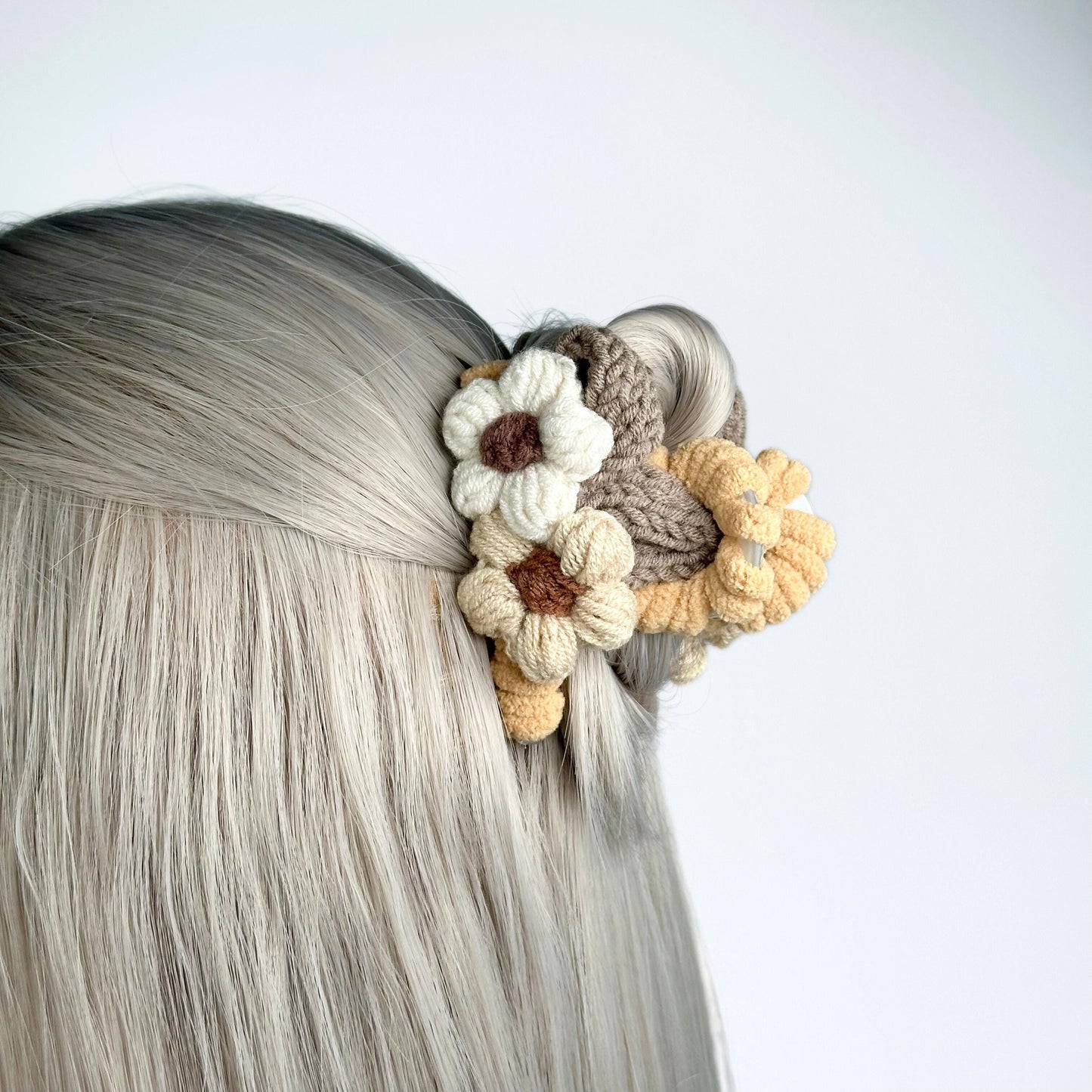 a close up of a woman's head with a crochet flower in
