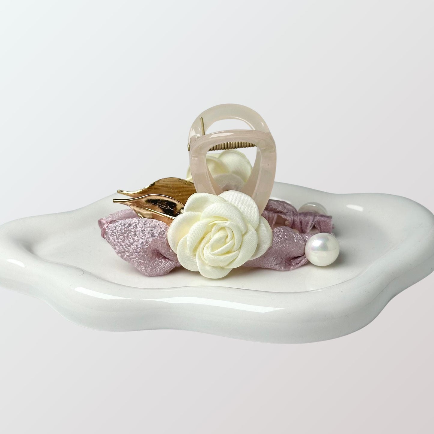 a white tray with a flower and a ring on it
