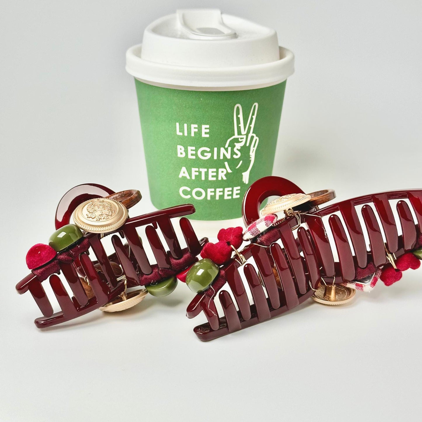 a cup of coffee next to some hair clips