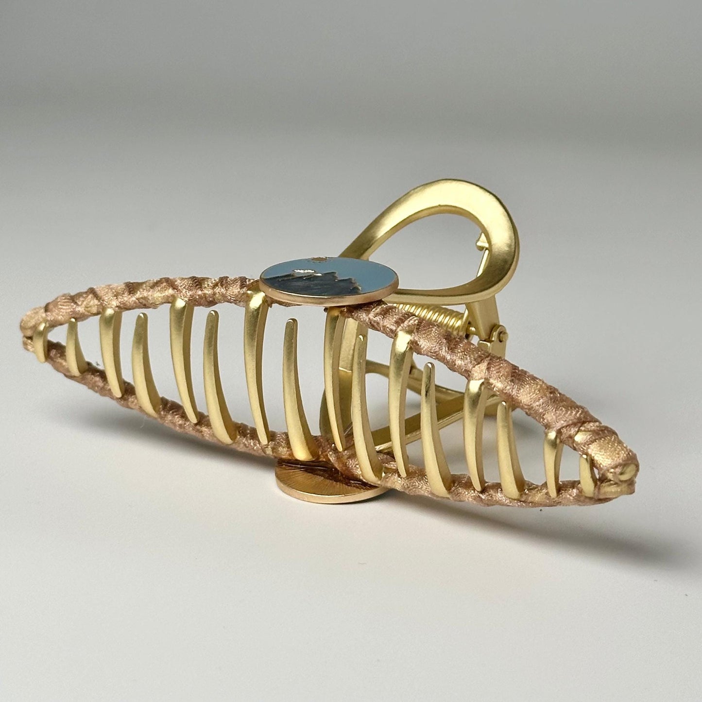 a gold metal object with a blue button on it