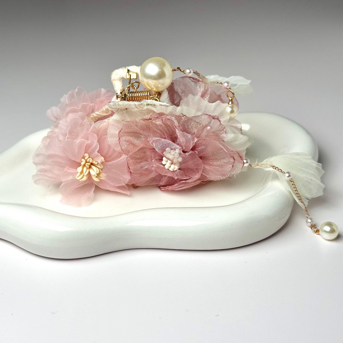 a white tray with a pink flower and a tiara on it