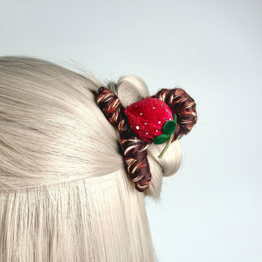 a close up of a woman's hair with a strawberry on it