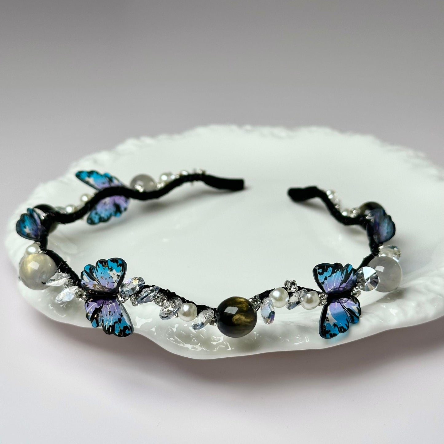a white plate topped with a blue butterfly bracelet