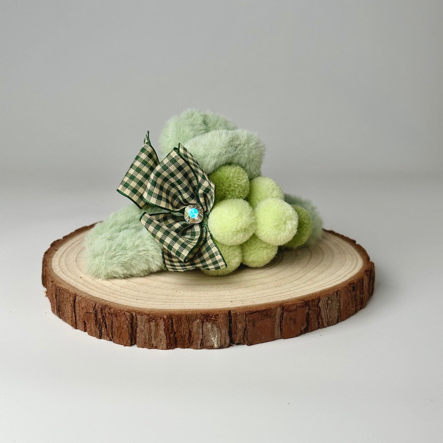 a green teddy bear sitting on top of a tree stump