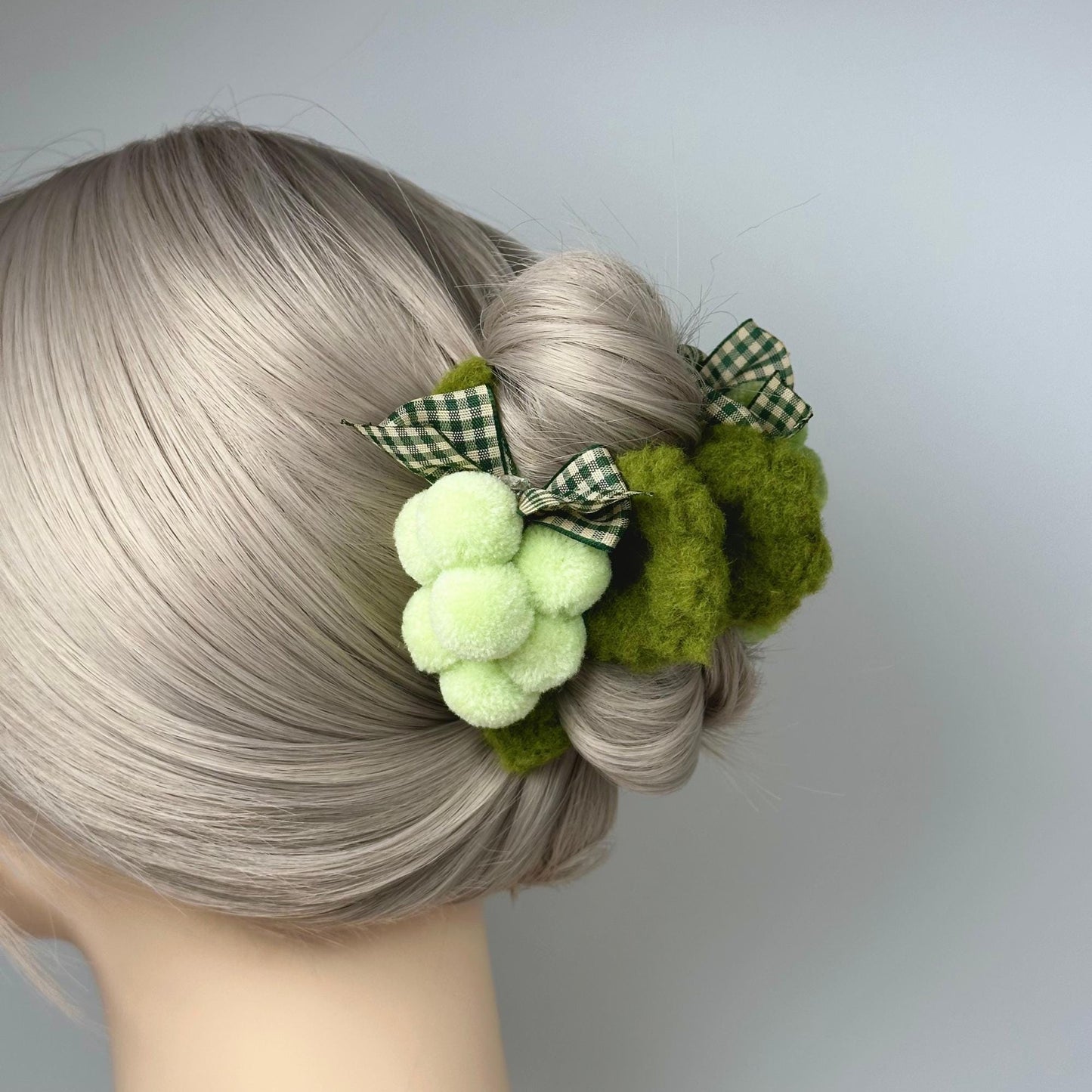 a close up of a woman's hair with a green pom pom