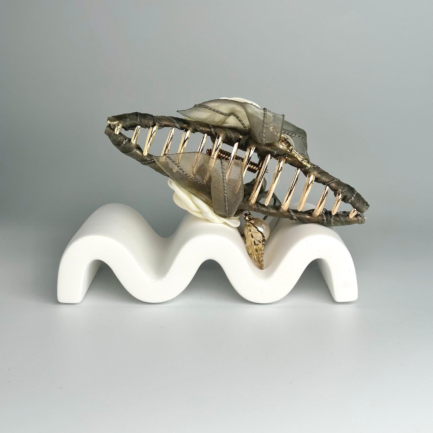 a sculpture of a leaf on a white base