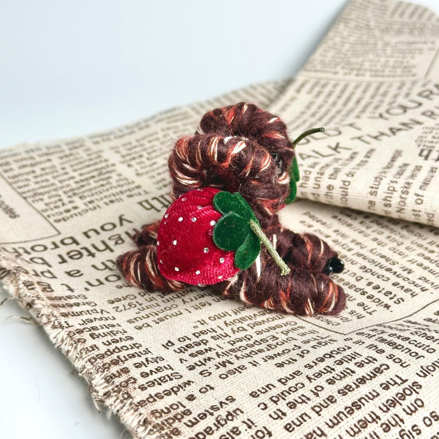 a red flower sitting on top of a newspaper