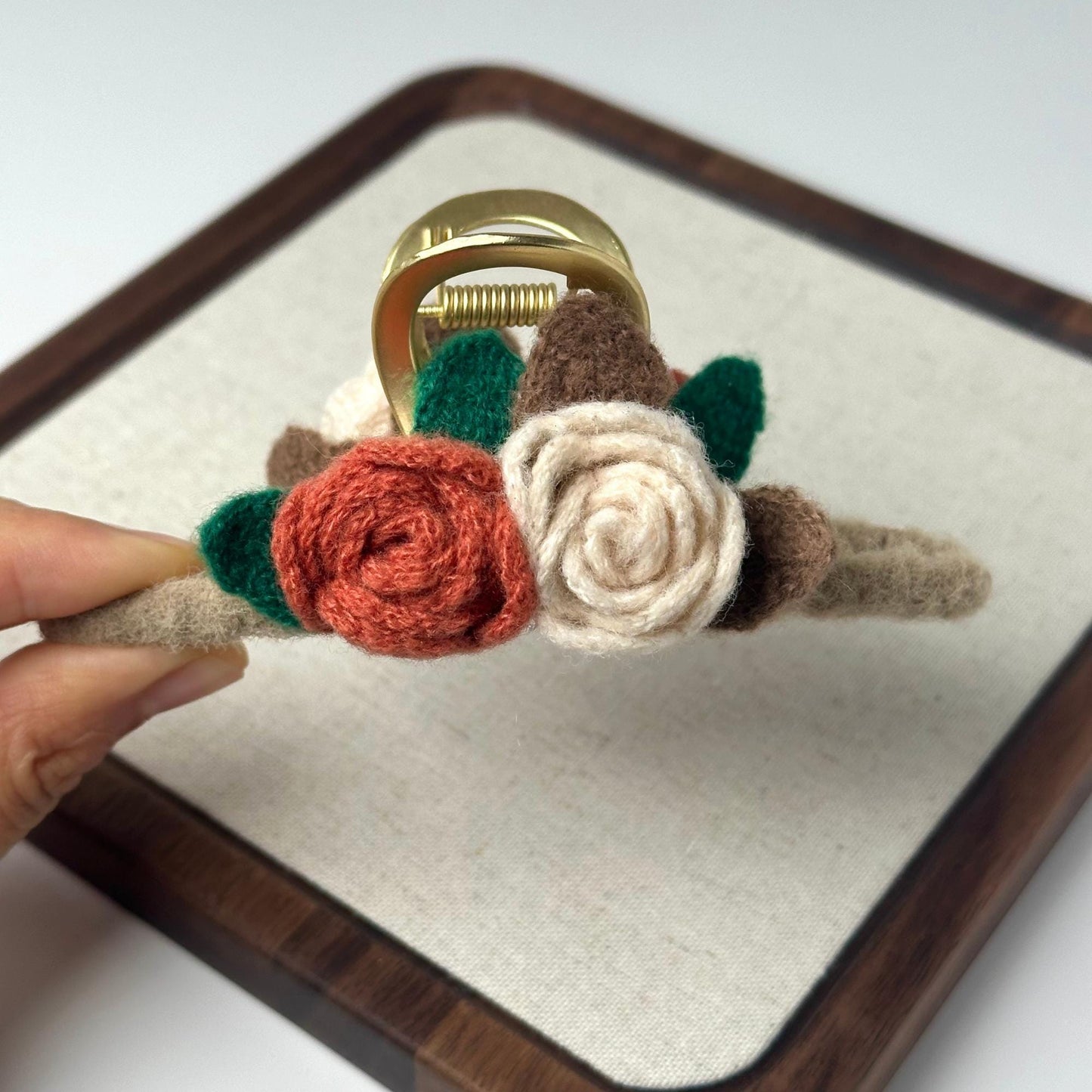 a person holding a ring with flowers on it