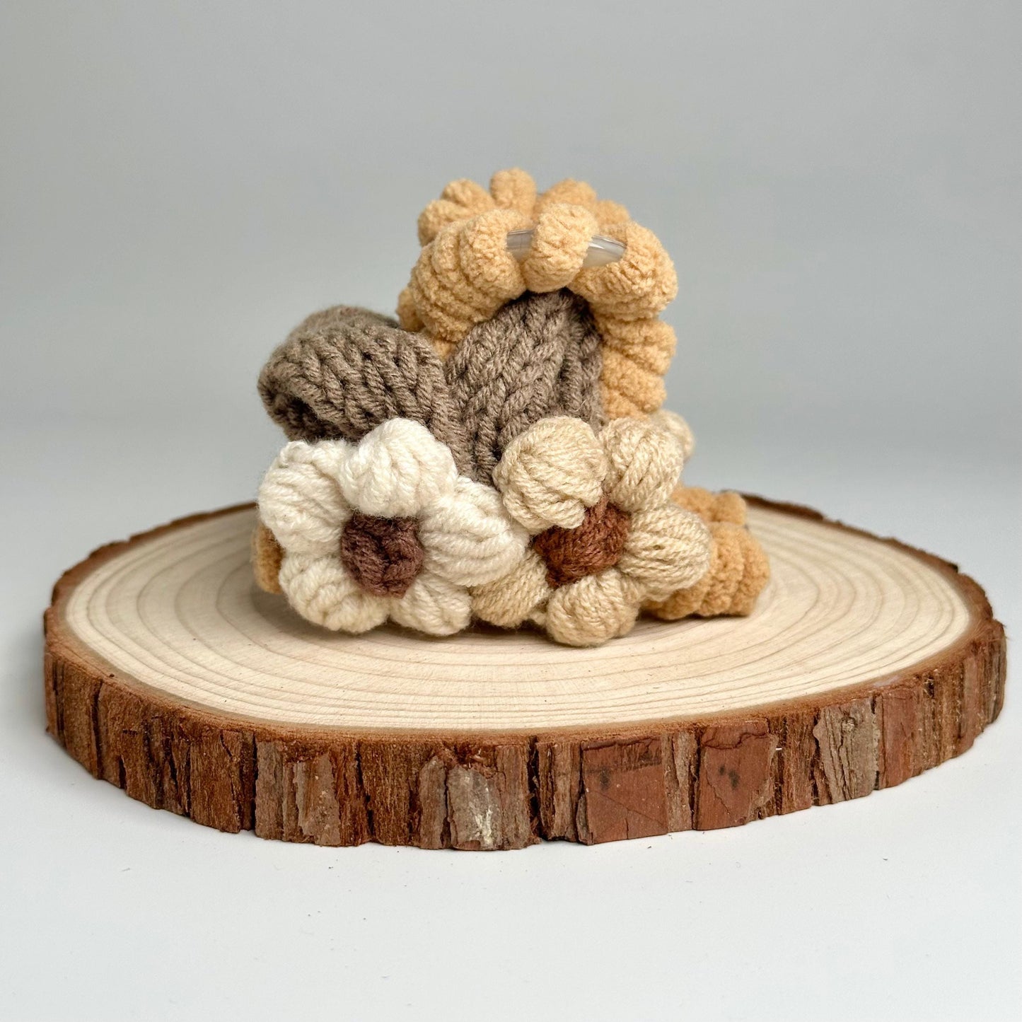 a small crocheted stuffed animal sitting on top of a tree stump