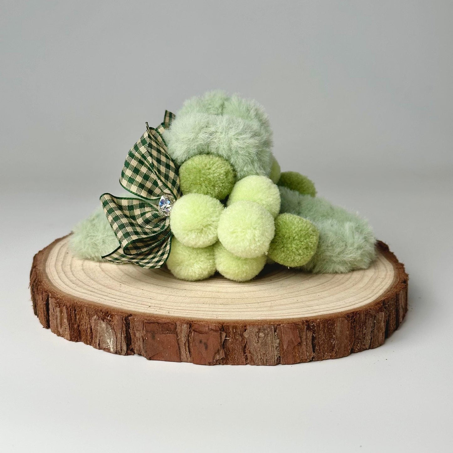 a green teddy bear sitting on top of a tree stump