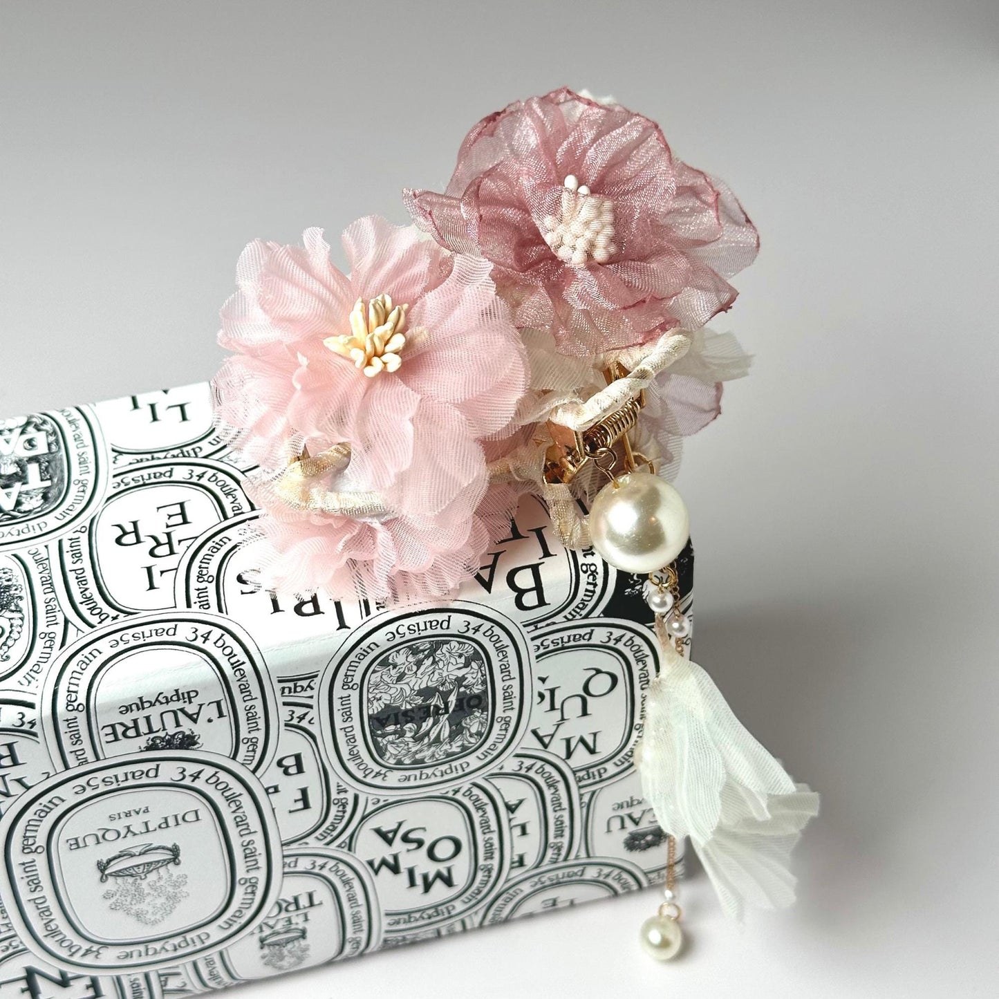two pink flowers sitting on top of a white box