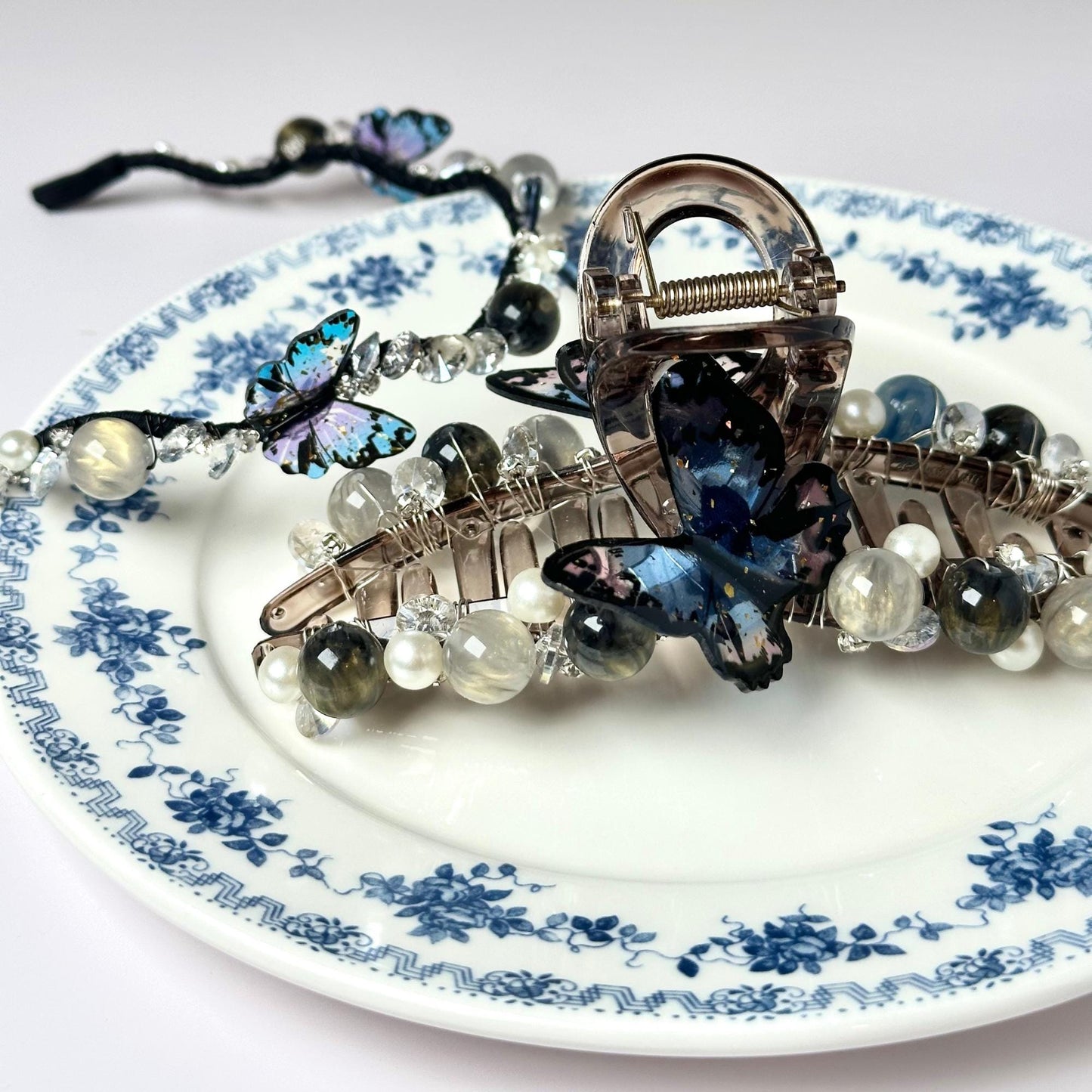 a blue and white plate with a bunch of jewelry on it