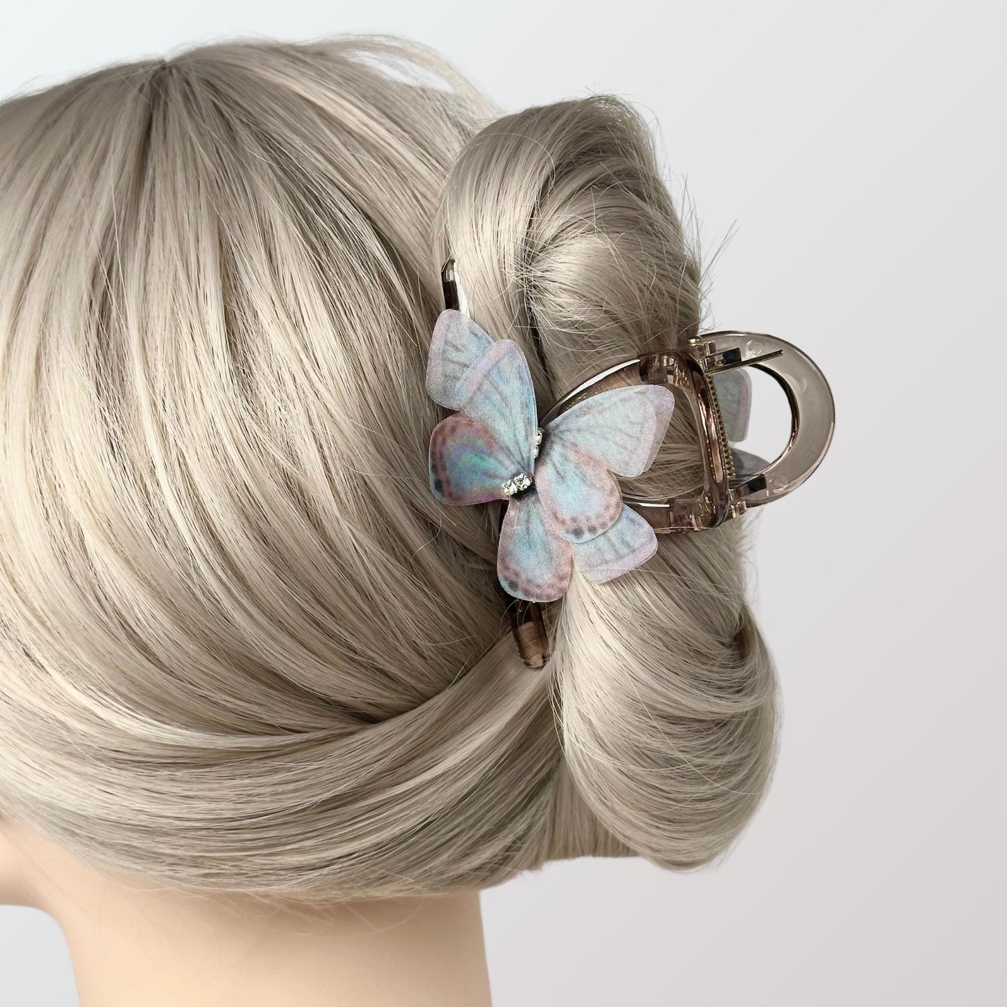 a woman with blonde hair and a butterfly hair clip