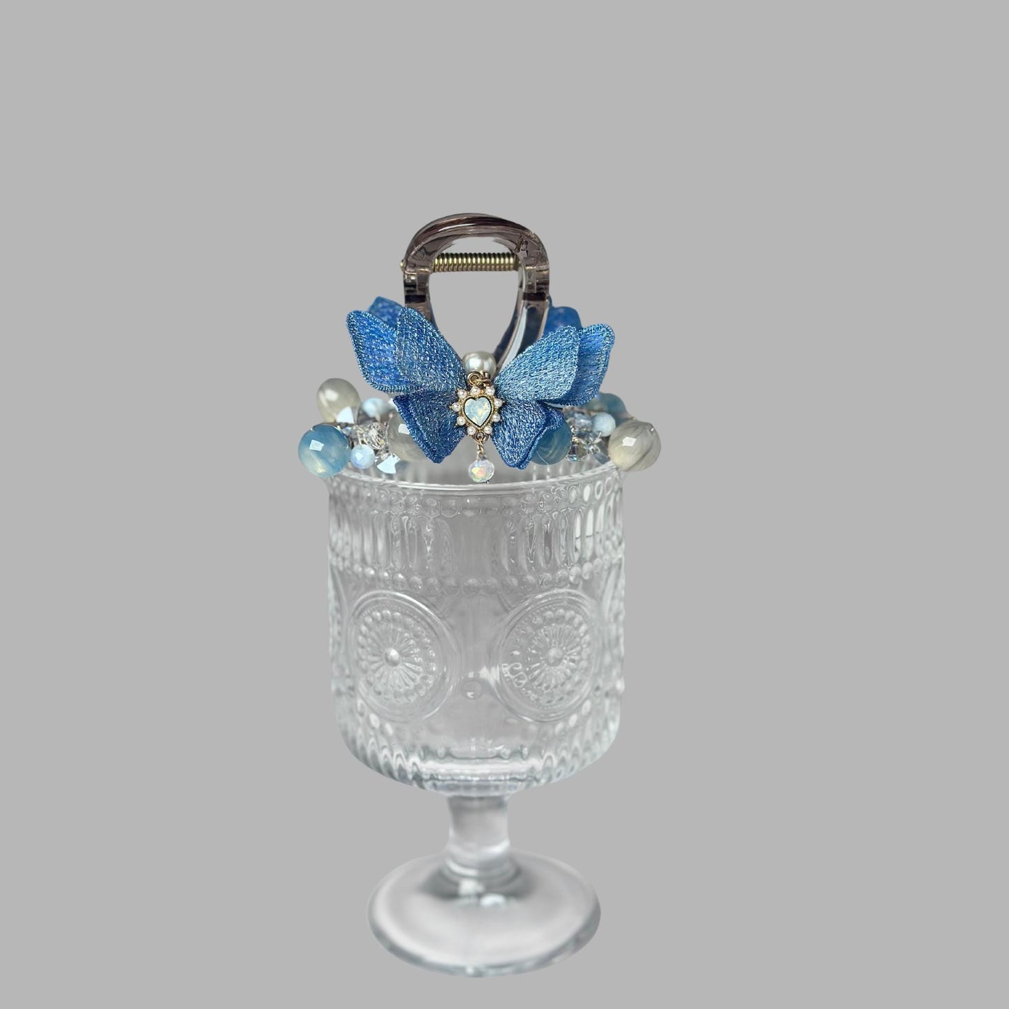 a glass vase with a handle decorated with blue flowers
