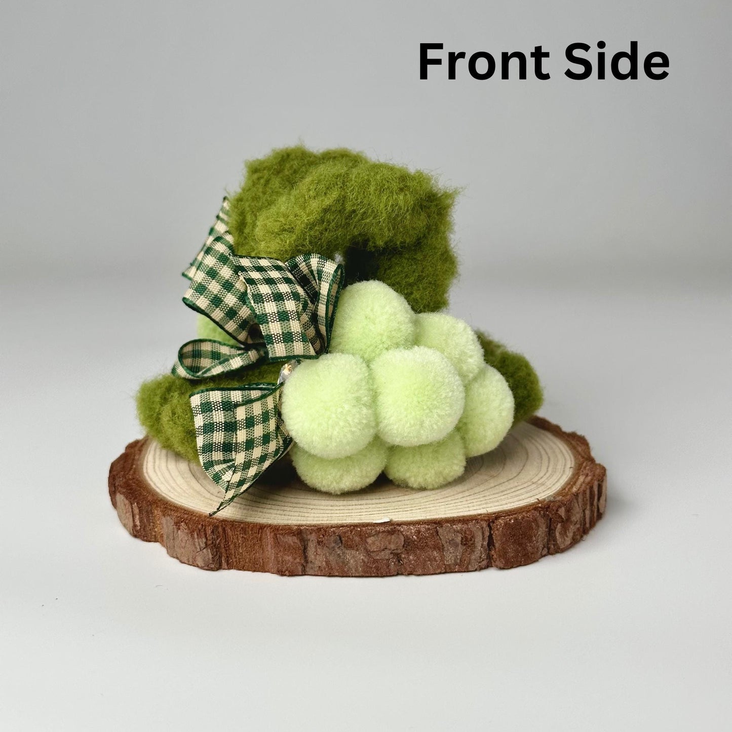 a green teddy bear sitting on top of a tree stump