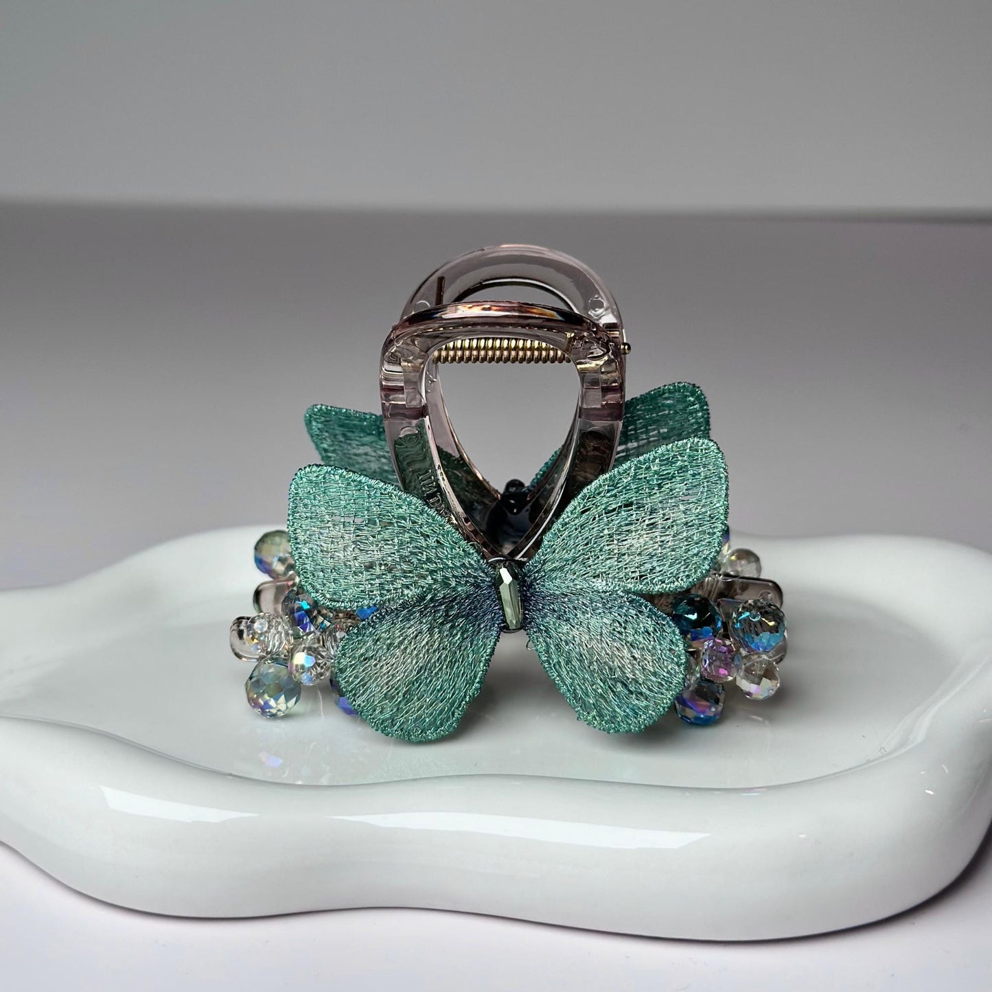 a ring with a bow on it sitting on a plate