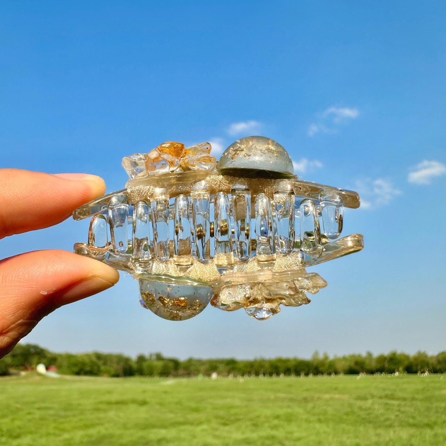 a hand holding a piece of glass in a field