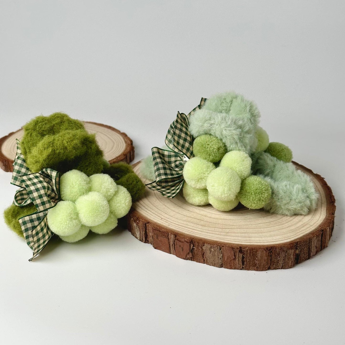 a green and white teddy bear sitting on a piece of wood