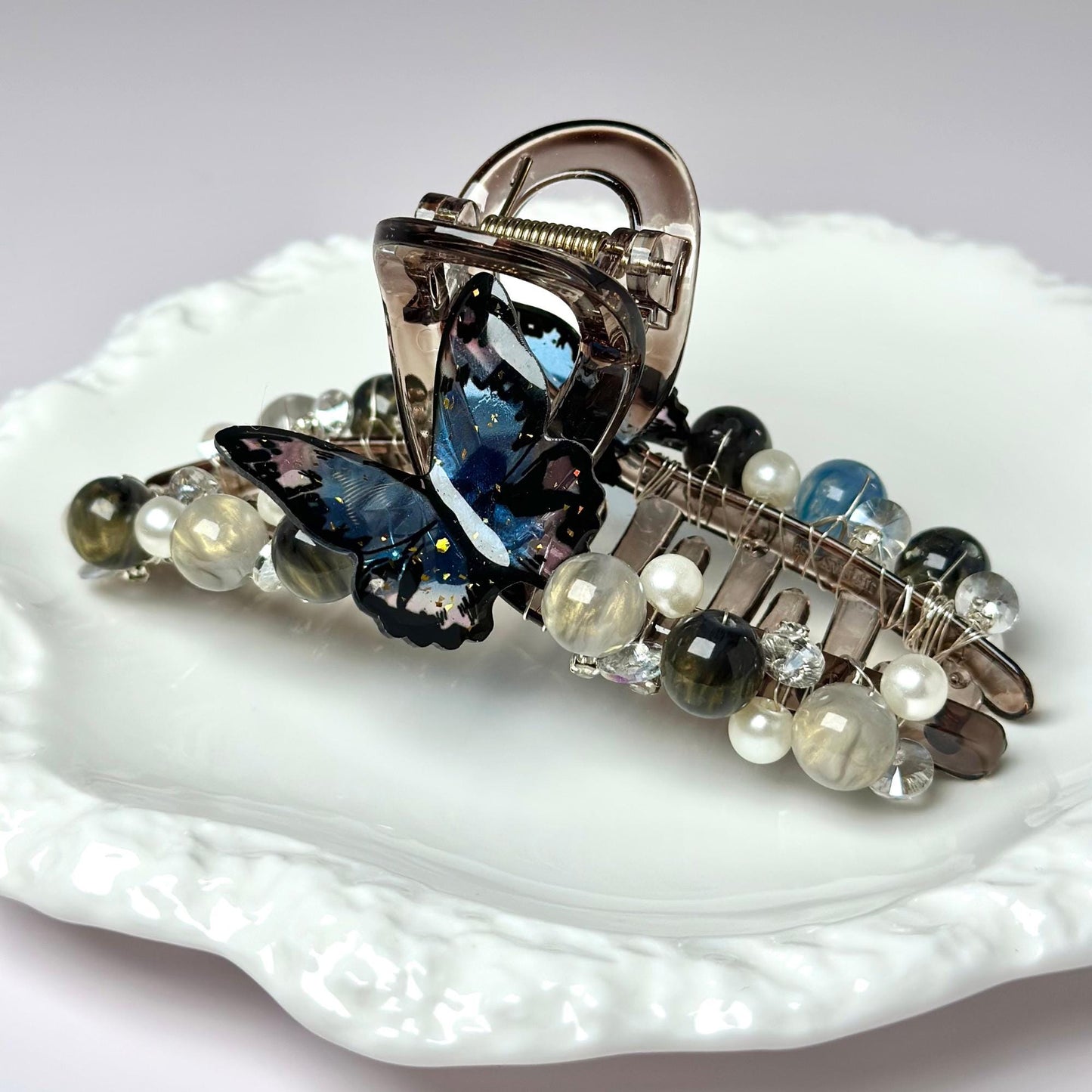 a white plate topped with a butterfly brooch