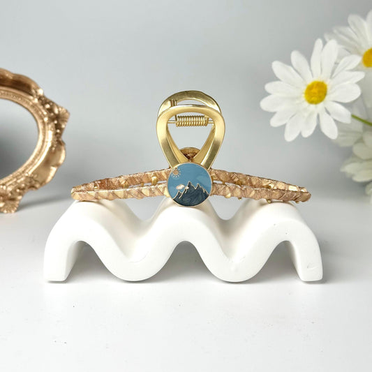 a gold ring with a blue stone sits on top of a white stand