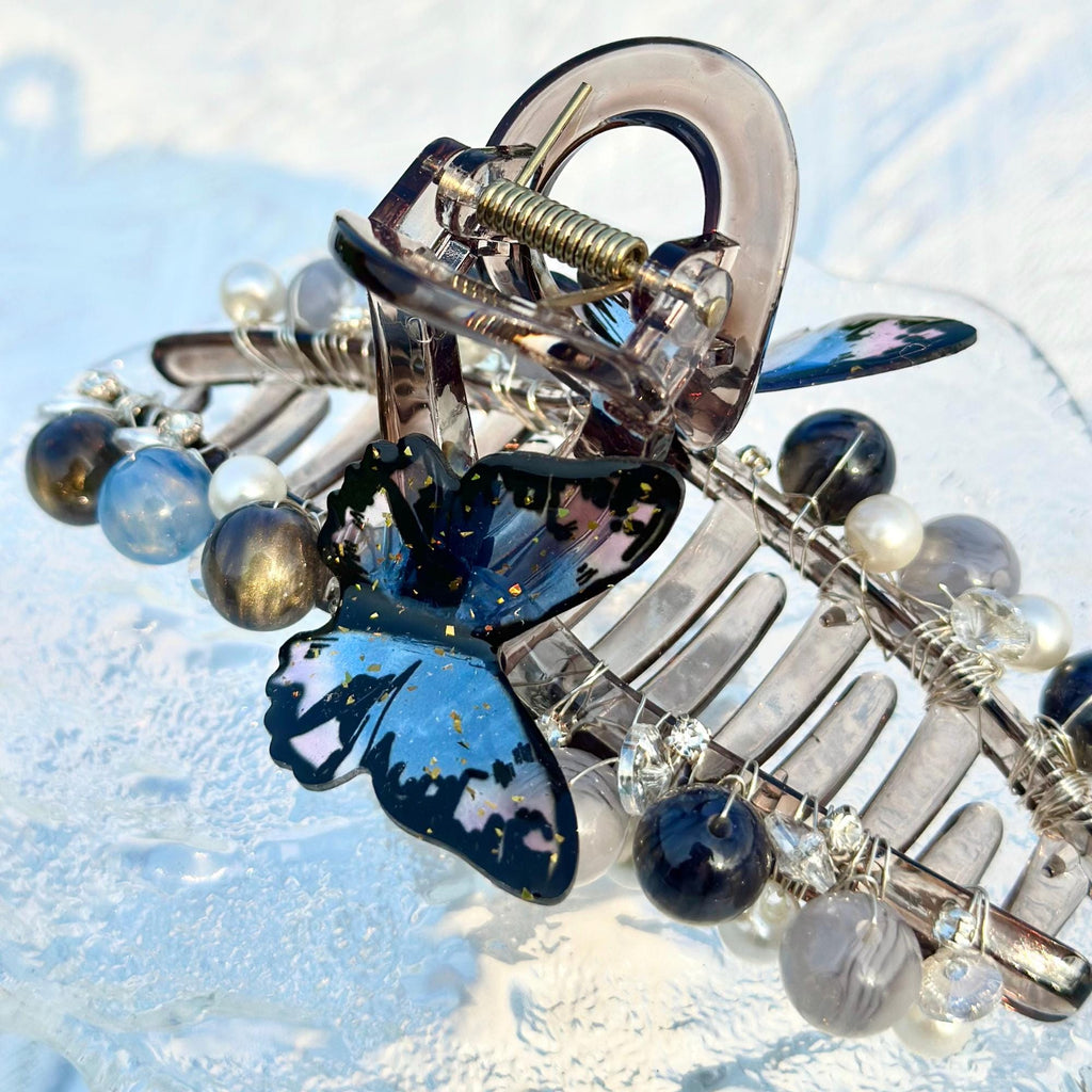 a close up of a brooch with a butterfly on it