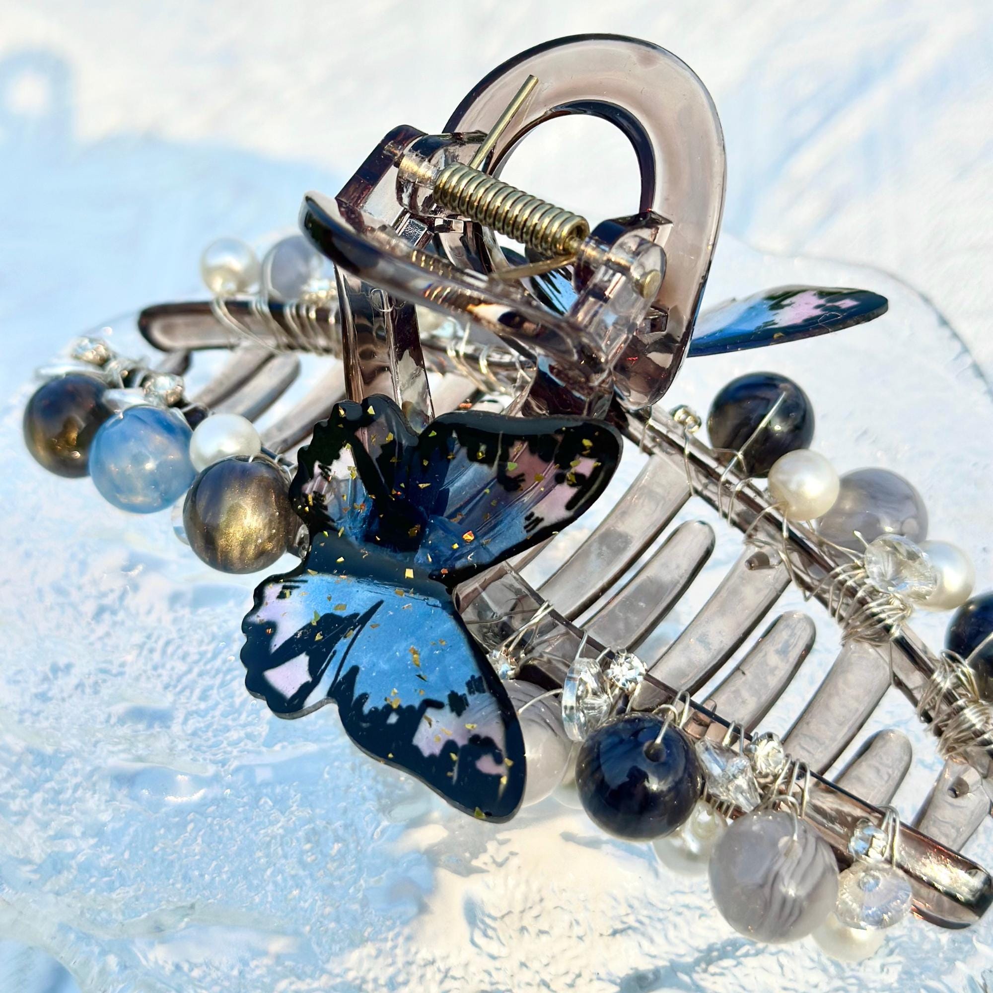 a close up of a brooch with a butterfly on it