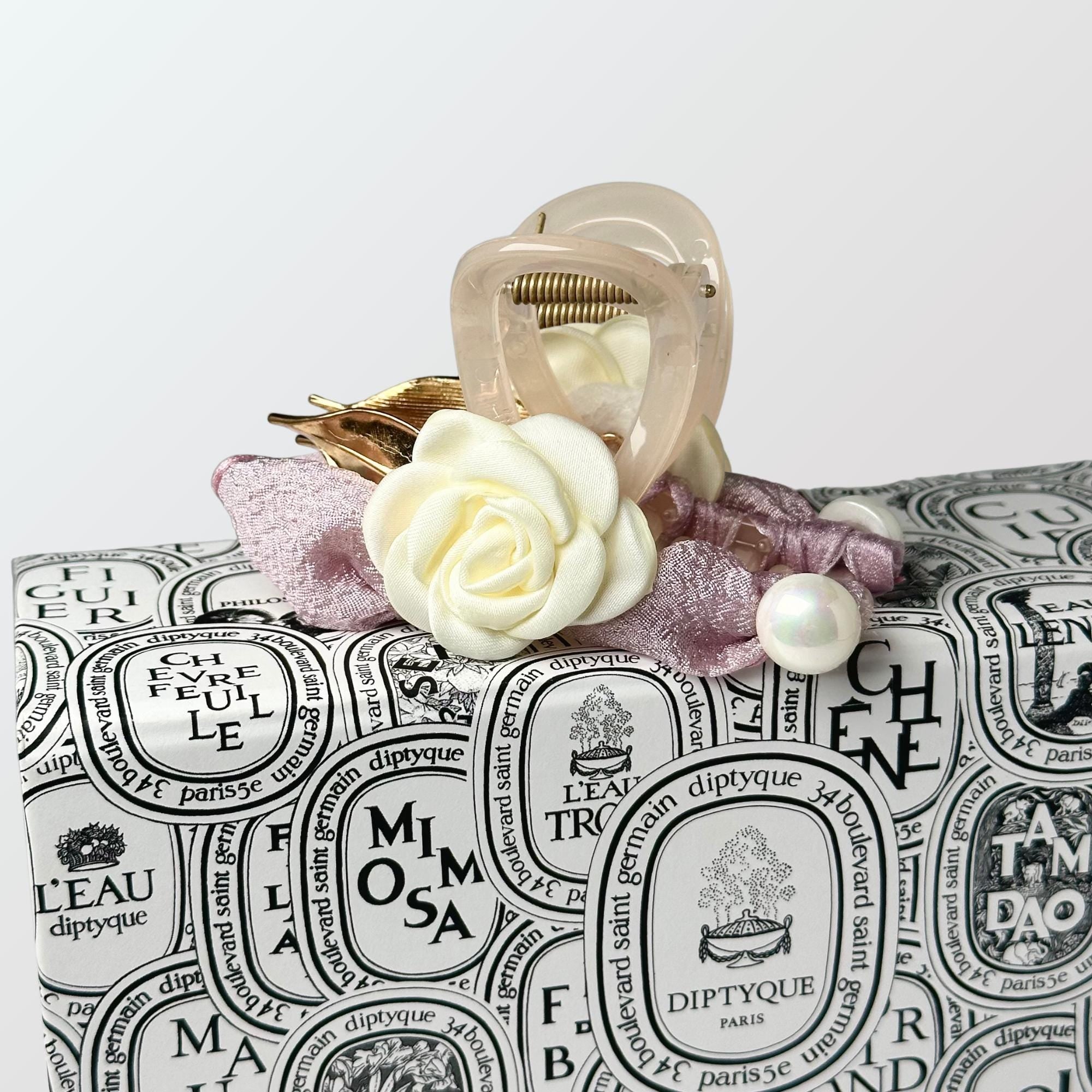 a white rose sitting on top of a black and white bag