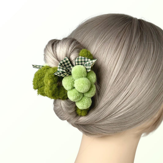 a close up of a woman&#39;s hair with a green flower in it