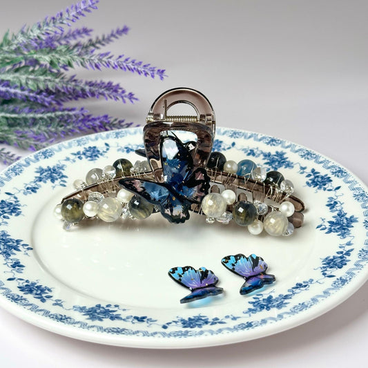 a blue and white plate with a butterfly brooch