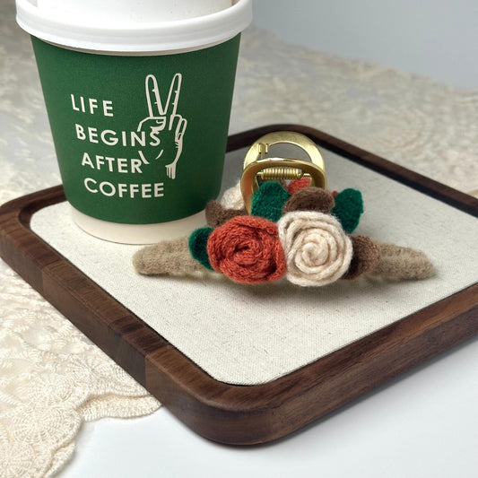 a coffee cup with a ring and a flower on a tray