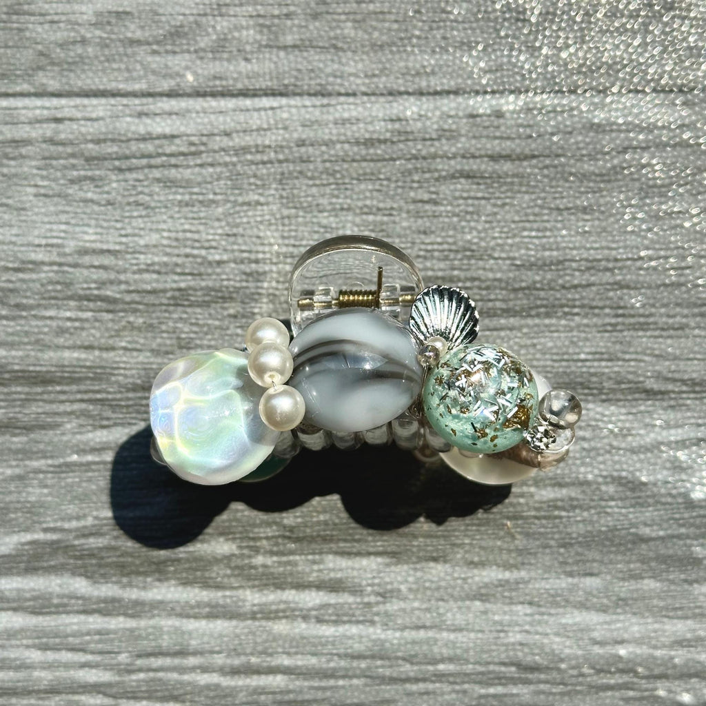 a ring with a shell and pearls on it