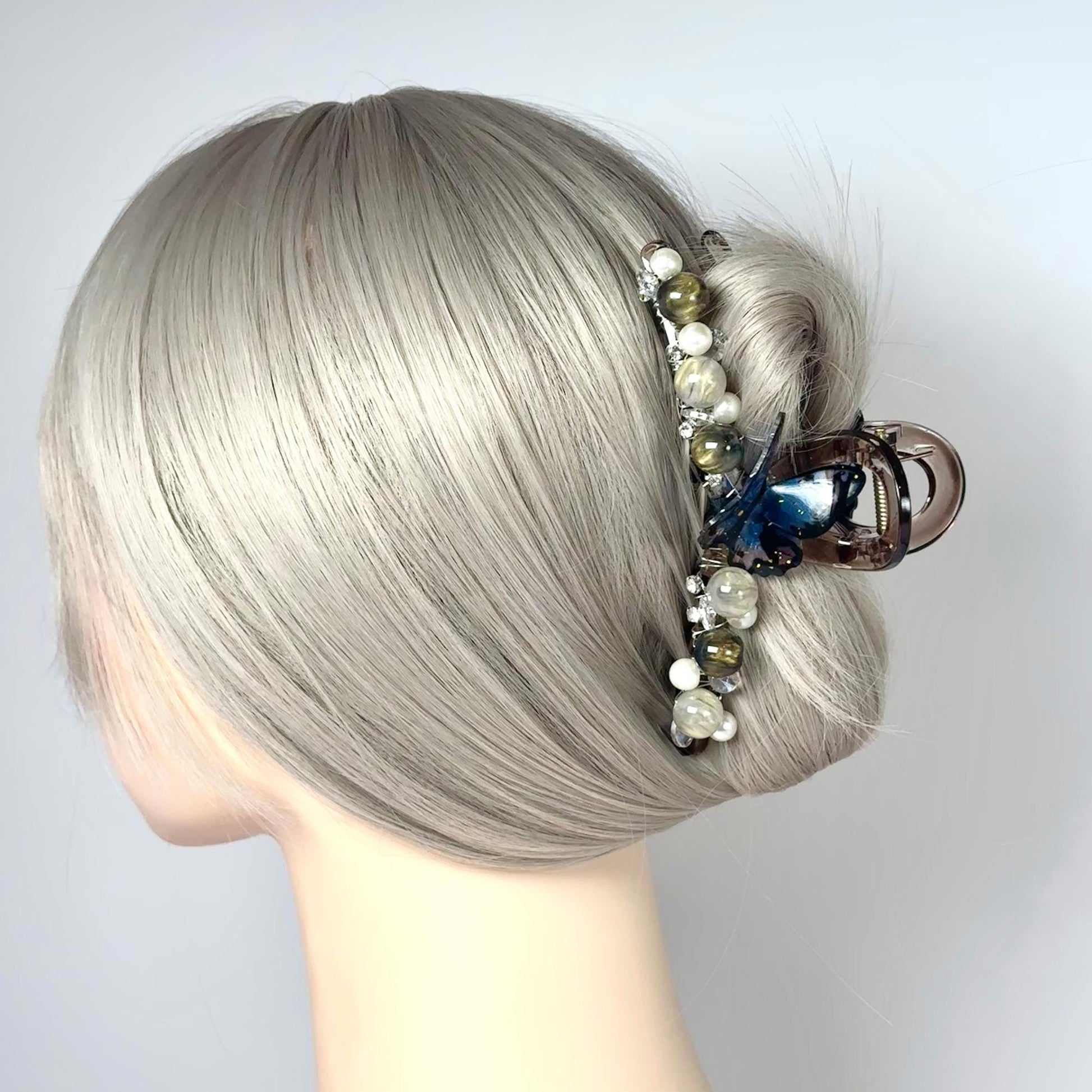 a woman&#39;s head with grey hair and a hair clip