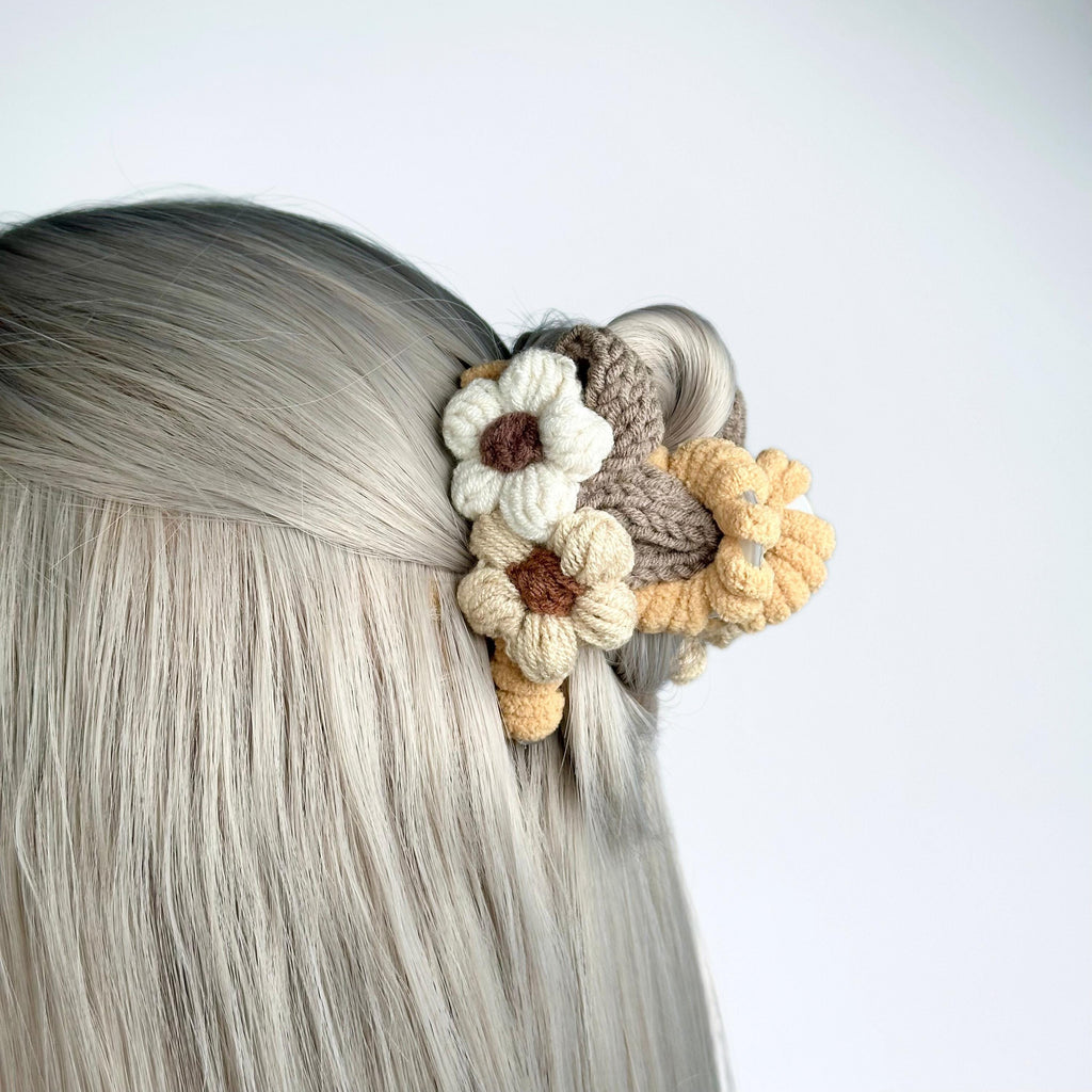 a close up of a woman's head with a crochet flower in
