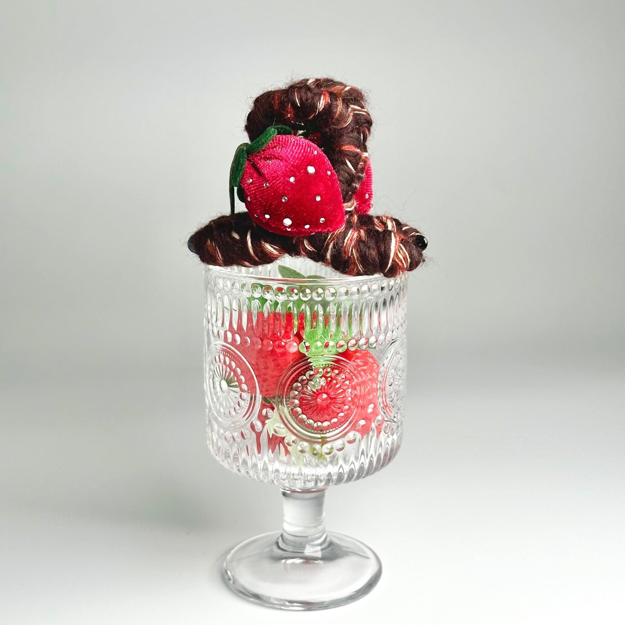 a glass vase with some strawberries in it
