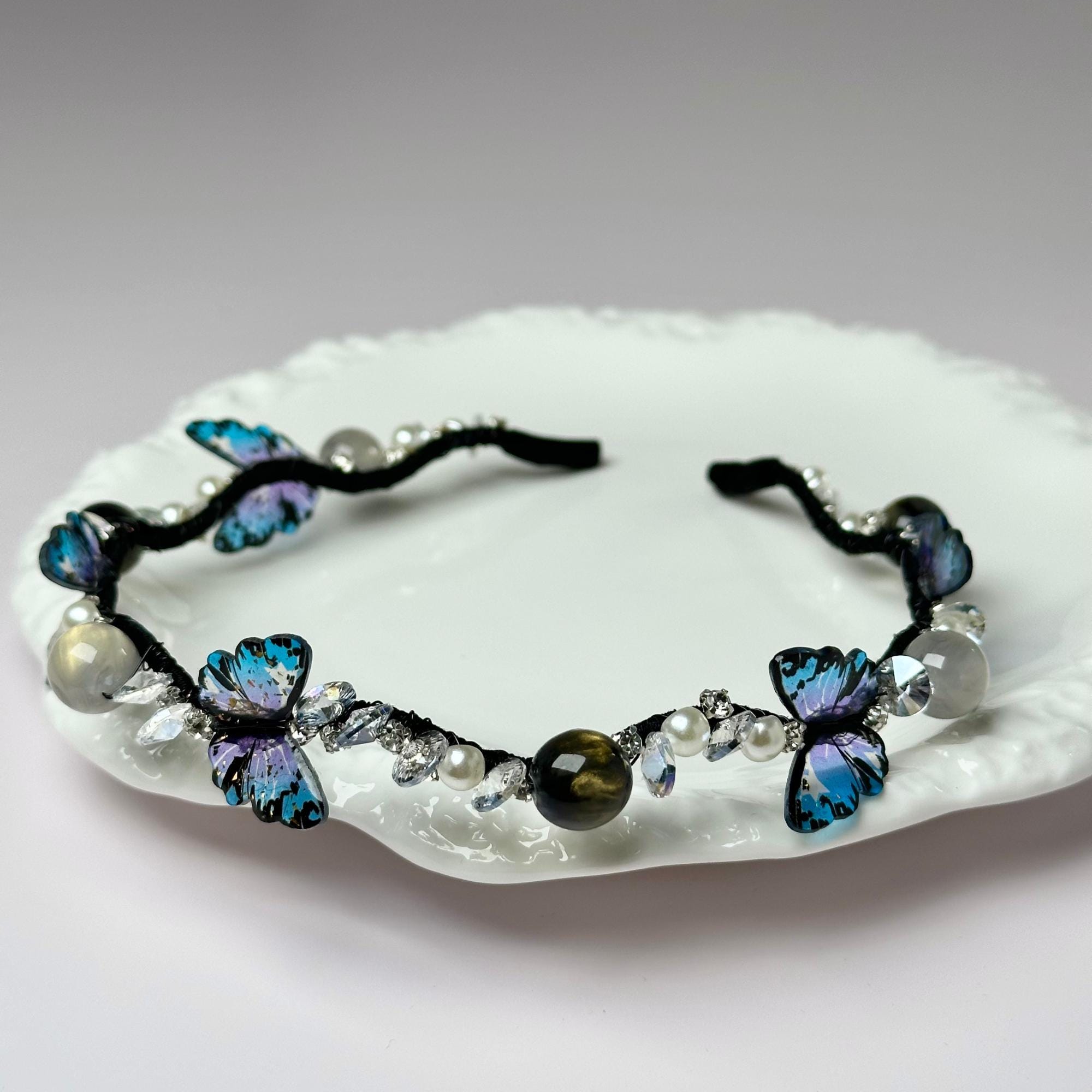 a white plate topped with a blue butterfly bracelet