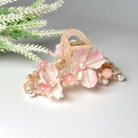 a pair of hair clips with flowers and pearls