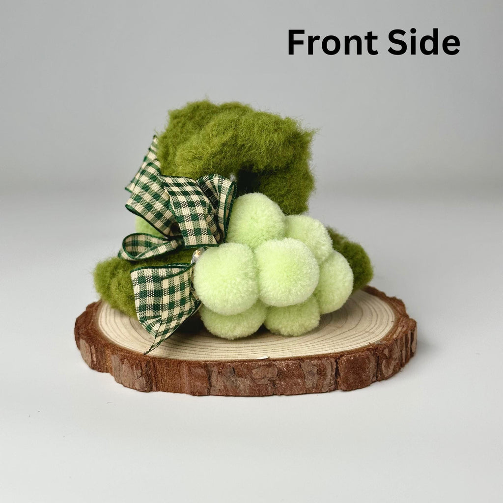 a green teddy bear sitting on top of a tree stump