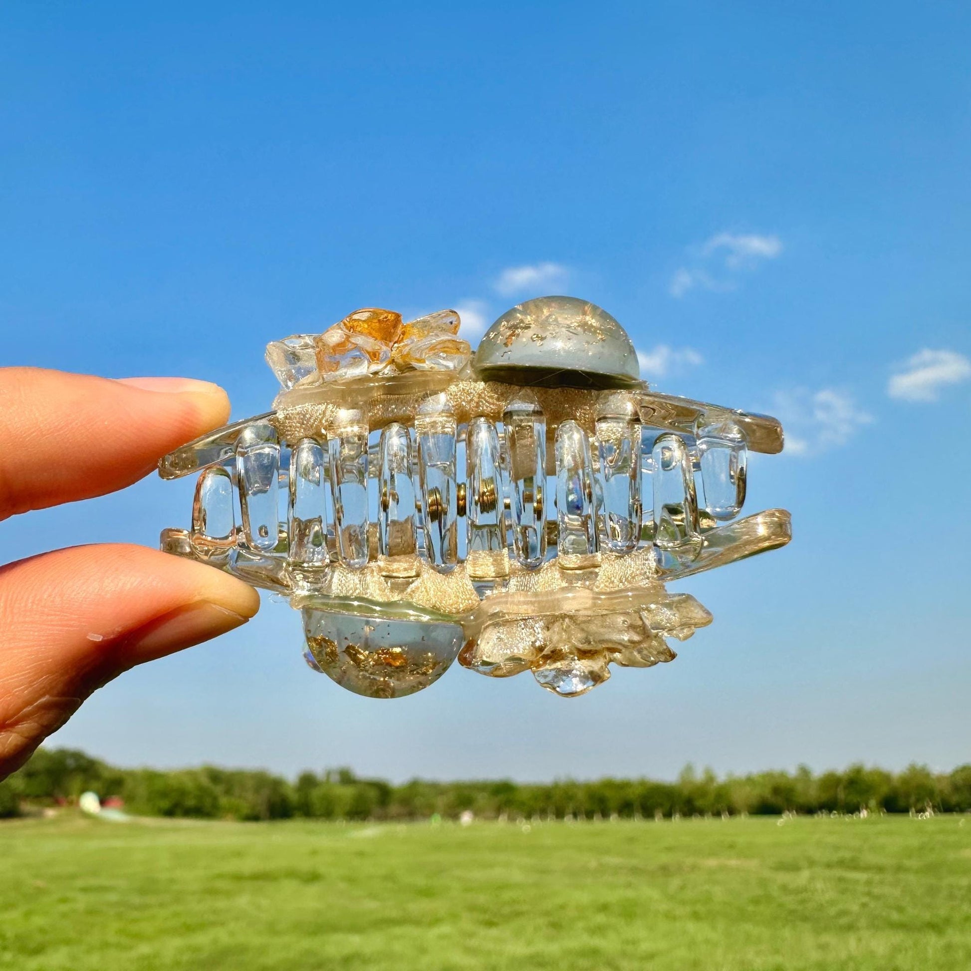 a hand holding a piece of glass in a field