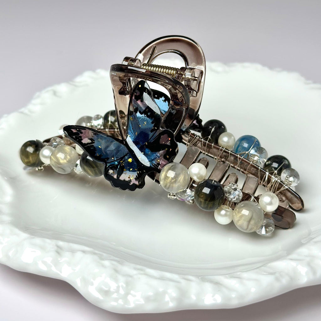 a white plate topped with a butterfly brooch